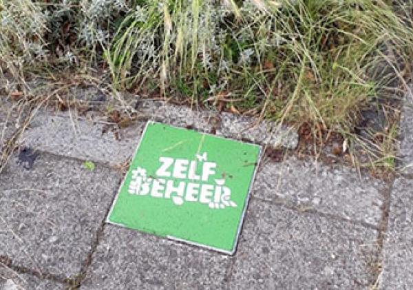 De zelfbeheertegel; een groene tegel met daarop in het wit de tekst: zelf beheer