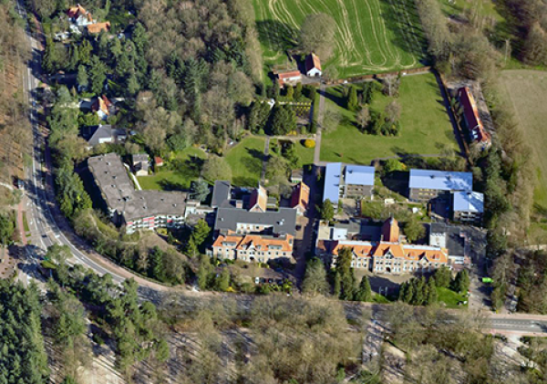 Luchtfoto van een aantal woningen in een groen landschap