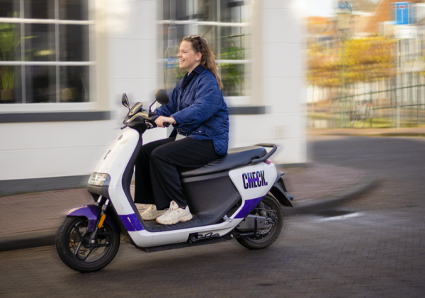 Foto van iemand die op een deelscooter rijdt