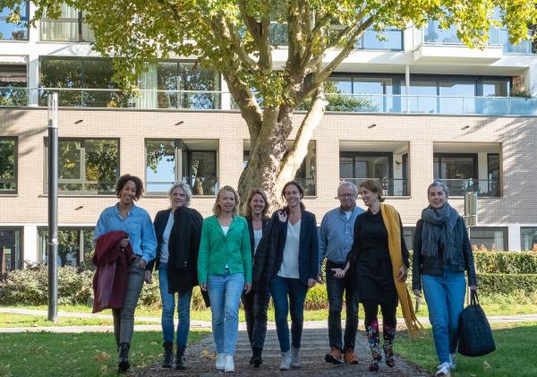 Coaches participatie en inkomen; 7 vrouwen en een man lopen in een rij over een voetpad