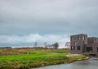 Vathorst Bovenduist, een gebouw en een grasgebied langs het water