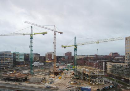 De bouwplaats voor het Huis van de Stad met drie grote hijskranen.